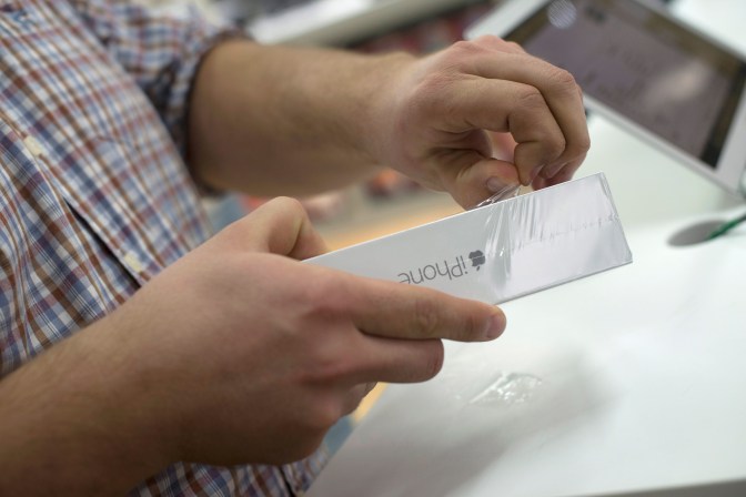 Budapest, 2014. október 31. Egy vásárló átveszi új iPhone 6-os készülékét az Apple amerikai számítástechnikai cég termékeit árusító iStyle boltban a budapesti Árkád Bevásárlóközpontban 2014. október 30-ról 31-re virradó éjjel. Az Apple október 31-én 0 óra 1 perckor megkezdte két új okostelefonja, az iPhone 6 és az iPhone 6 Plus készülékek hivatalos magyarországi forgalmazását. MTI Fotó: Kallos Bea