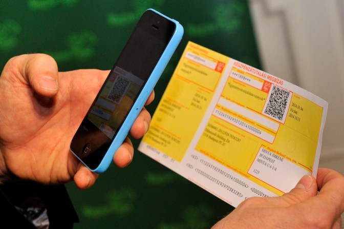 Budapest, 2014. október 30. Szarka Zsolt, a Magyar Posta Zrt. vezérigazgatója bemutatja az icsekk fizetéséhez szükséges, mobiltelefonra tölthetõ applikációt budapesti sajtótájékoztatóján 2014. október 30-án. A csekken szereplõ QR-kód segítségével már mobiltelefonon is be lehet fizetni az összeget bankkártyával, amely nem minõsül készpénzfelvételnek. MTI Fotó: Kovács Attila