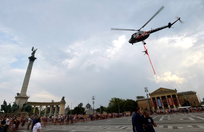 Budapest, 2015. július 18. Vinzce Tünde artista, légtornász egy helikopteren függeszkedve tart bemutatót a Cirkuszok éjszakája nyitó eseményén a fõvárosi Hõsök terén 2015. július 18-án. MTI Fotó: Máthé Zoltán