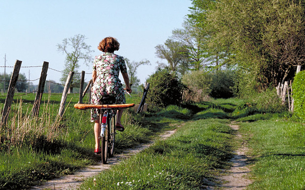 Elk129 3161 France Normandy woman riding bicycle with baguette...B5MG58 Elk129 3161 France Normandy woman riding bicycle with baguette