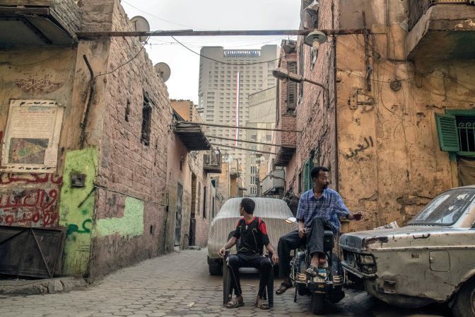 Kairó, 2015. augusztus 13. Férfiak a pokolgépes támadás célpontjává vált kairói olasz konzulátus mögötti nyomornegyedben, a Ramses Hilton szállodával a háttérben 2015. augusztus 4-én. Az úgynevezett Maspero-háromszög, az egyiptomi fõváros egyik legdrágább területén álló házak számos családját kilakoltatás fenyegeti. A fõvárost magába foglaló Kairó tartomány kormányzója szerint a lerombolásra ítélt házak a detonáció miatt életveszélyessé váltak, a lakók viszont azt gyanítják, hogy anyagi érdekek miatt kell távozniuk. MTI Fotó: Máté Bence