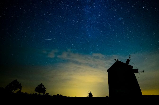 Tés, 2015. augusztus 13. Egy meteor látszik az égbolton Tés község két szélmalma felett 2015. augusztus 13-án. A Föld belépett a Perseida meteorraj összetevõit alkotó 109P/Swift-Tuttle üstökös pályája mentén szétszórt porfelhõbe. MTI Fotó: Komka Péter