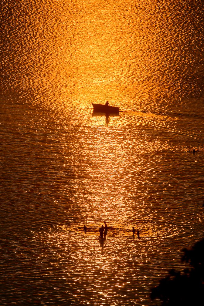 Balatonvilágos, 2015. augusztus 11.  Fürdõzõk és egy csónak a Balatonon naplementekor Balatonvilágosról fotózva 2015. augusztus 10-én. MTI Fotó: Komka Péter