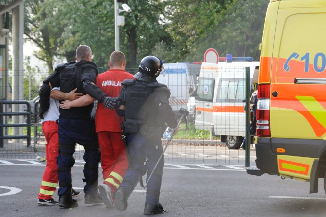 Röszke, 2015. szeptember 16. Mentõk kísérnek egy sérült rendõrt, miután migránsok kõvel dobálták a magyar rendõröket Röszke-Horgos határátkelõhely szerb oldaláról 2015. szeptember 16-án. MTI Fotó: Kelemen Zoltán Gergely